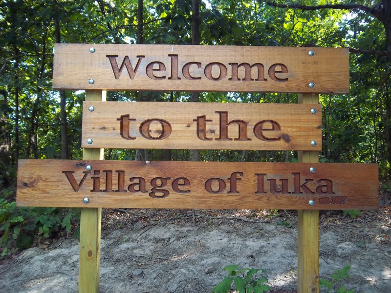 wooden sign, reads welcome to the village of Iuka