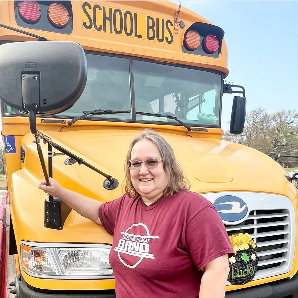 Bus driver in front of school bus