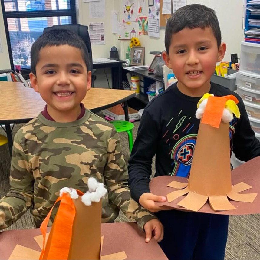 Elementary sstudents holding up their volcano projects