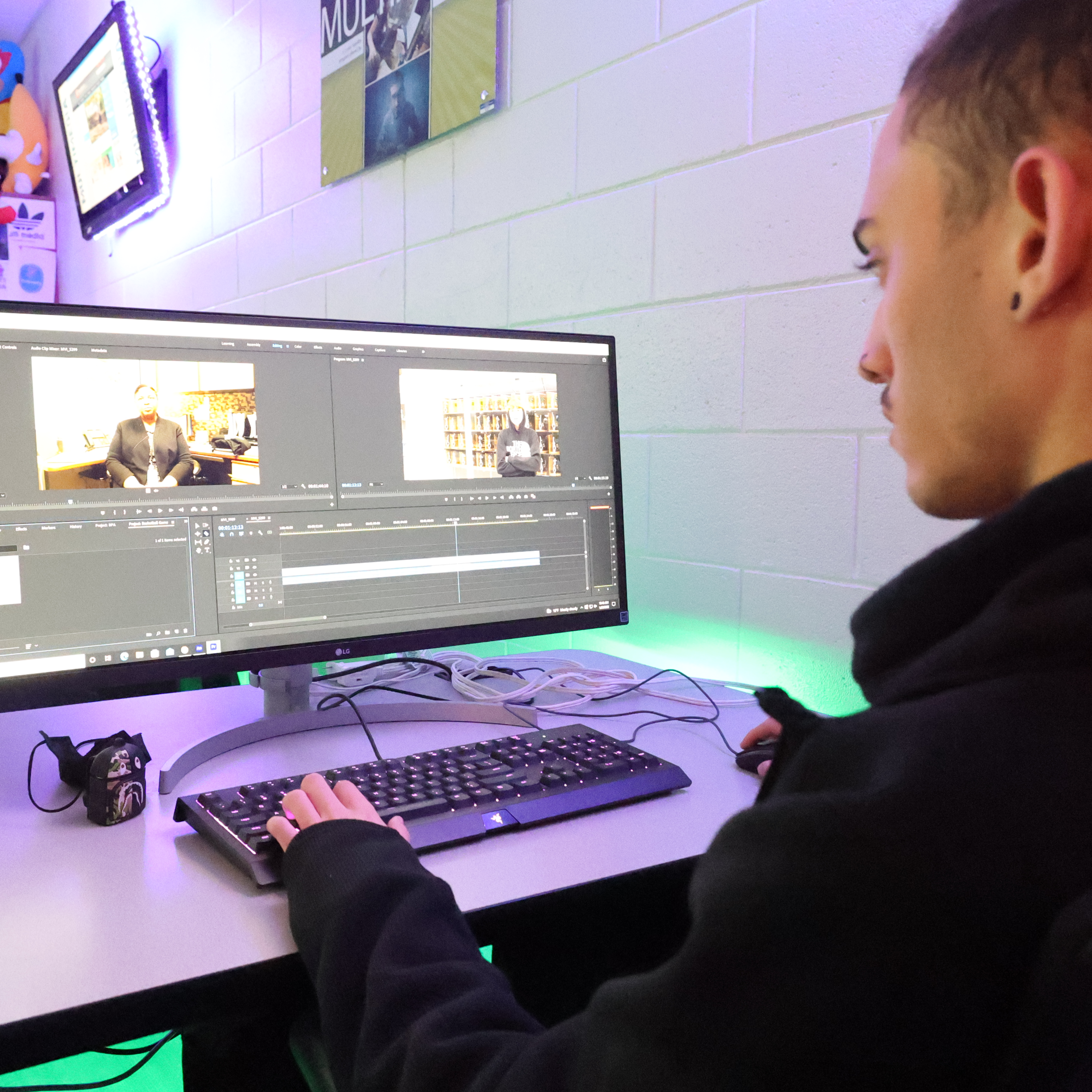 The camera shoot over the shoulder of a student to capture his digital artwork on his screen.