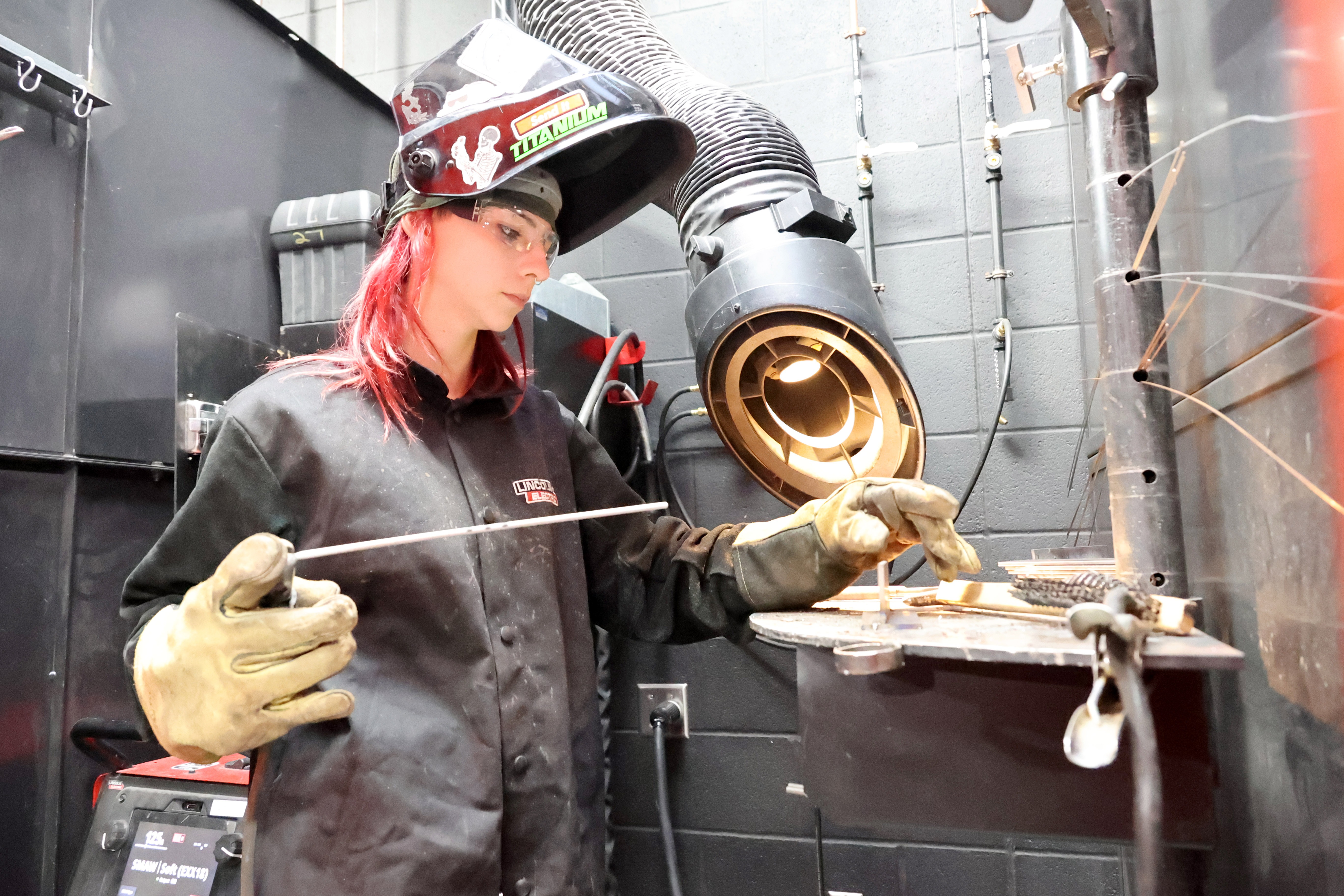 A welder preparing to weld in their booth.