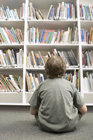 Kid sitting in front of bookshelf