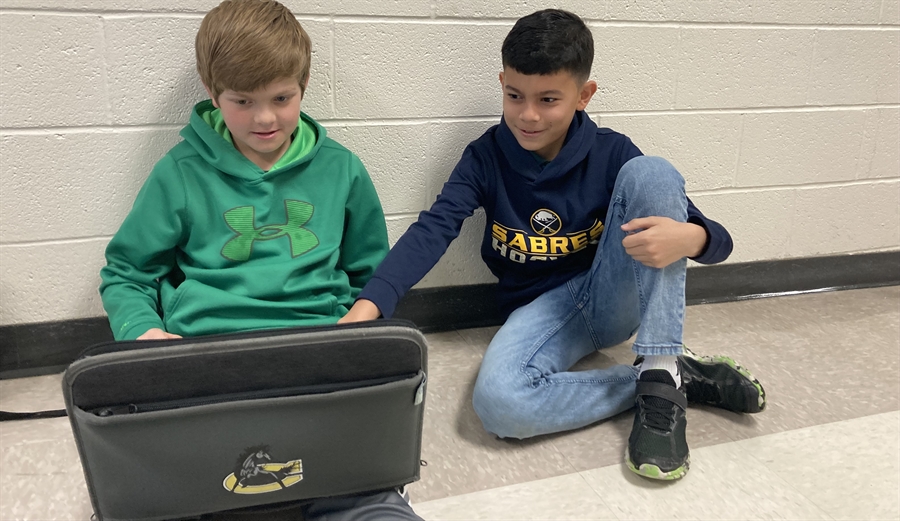 two boys using a chromebook