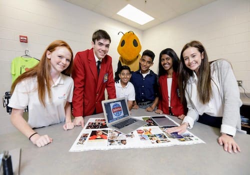 Graphic Design students with their mascot behind them
