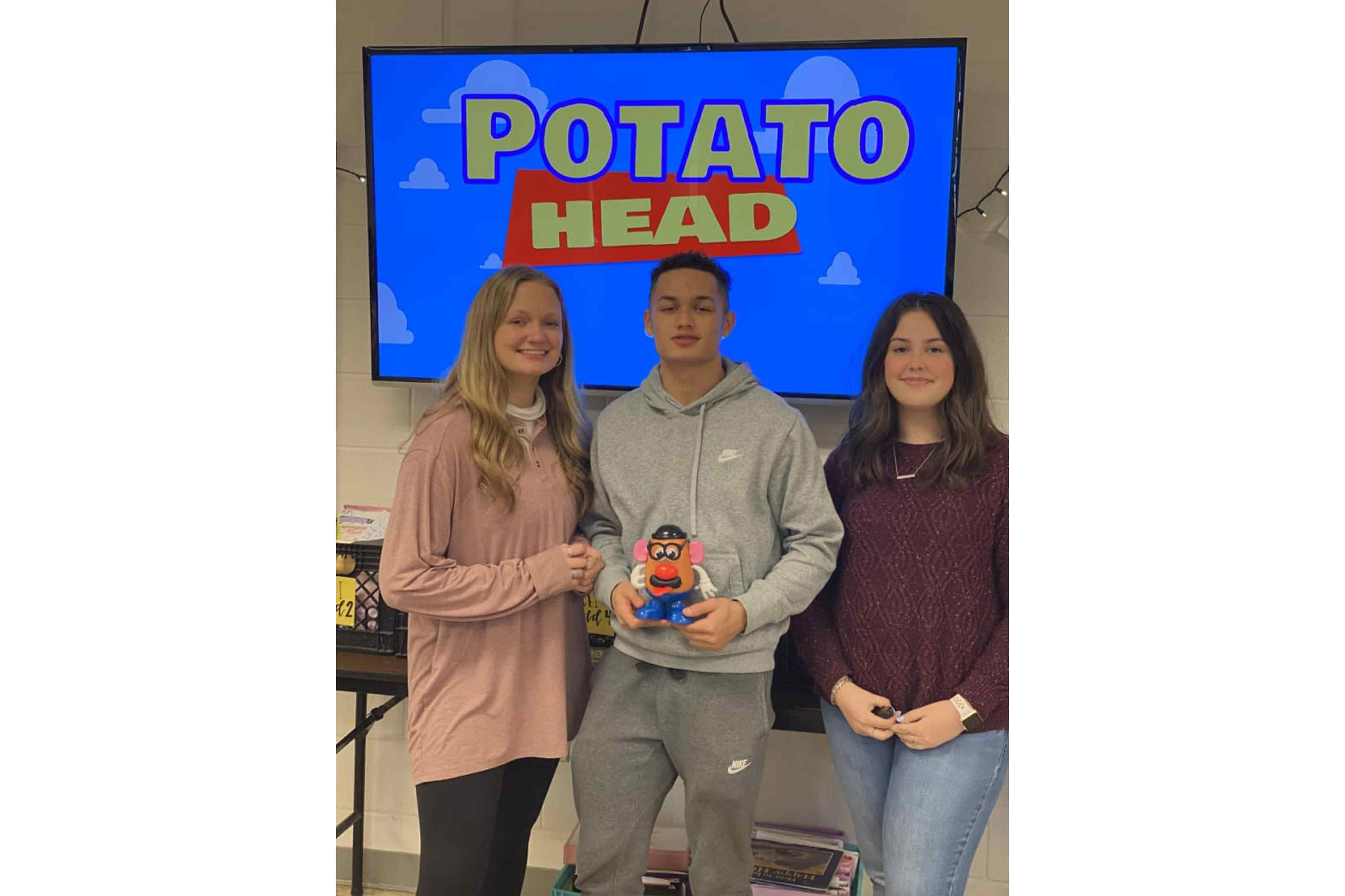 Students holding a Mr. Potato Head