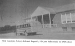 black and white photo of Old schoolhouse with bus in front 