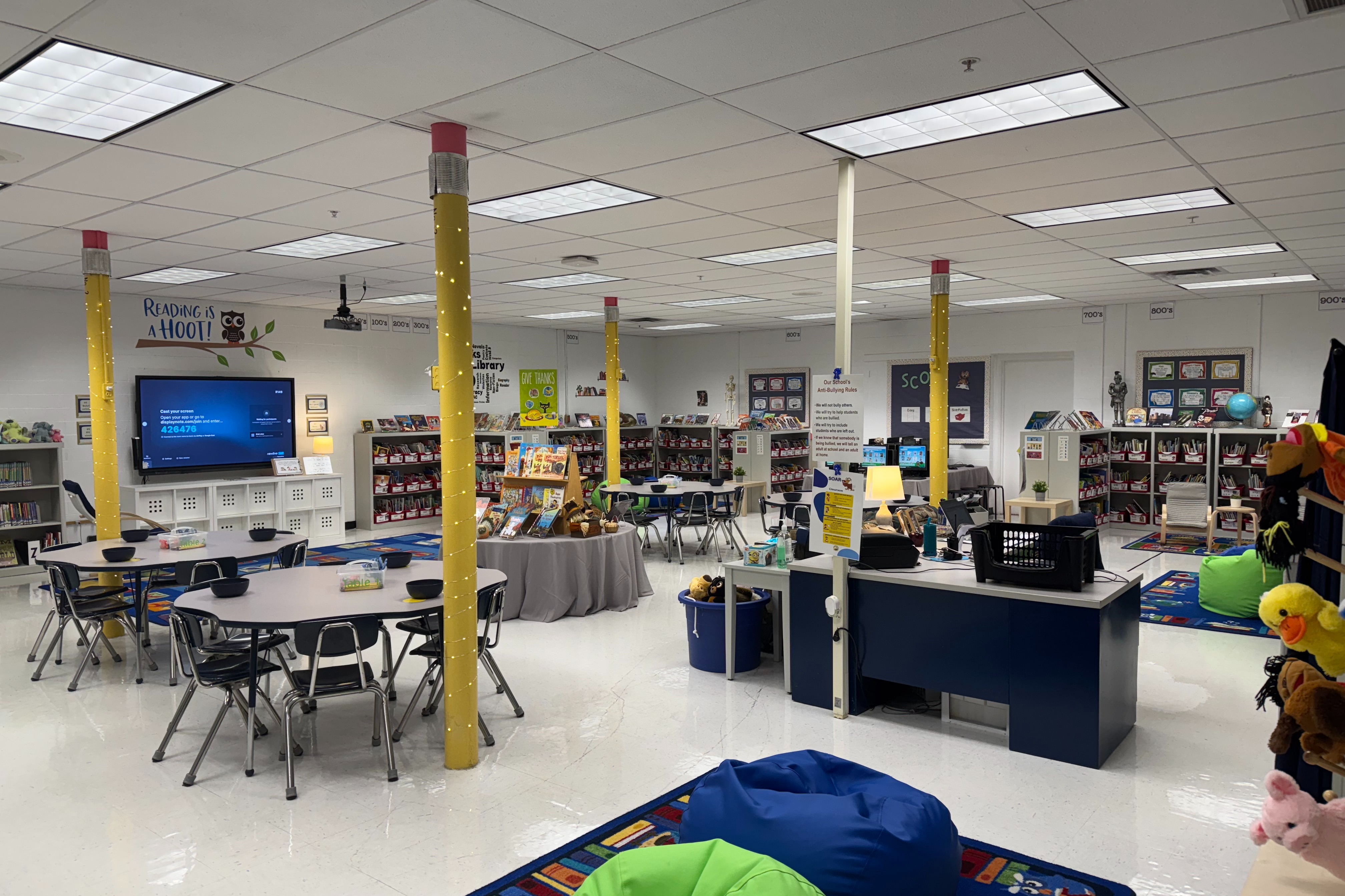 photo of library with tables and chairs and a checkout desk