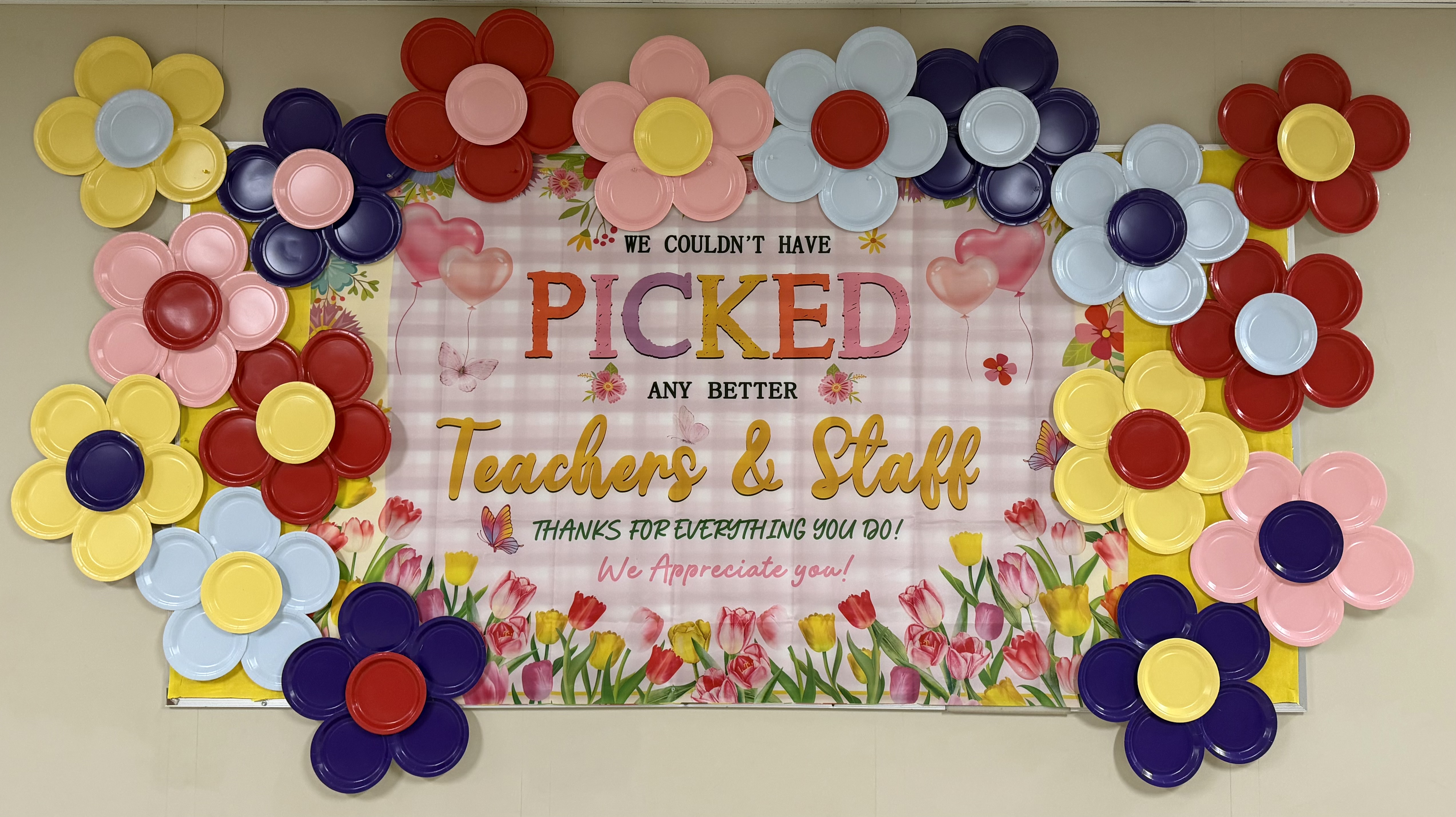 photo of a bulletin board covered in handmade paper plate flowers  that says, "we couldn't have picked any better teachers and staff.  Thank you for all that you do! We appreciate you!