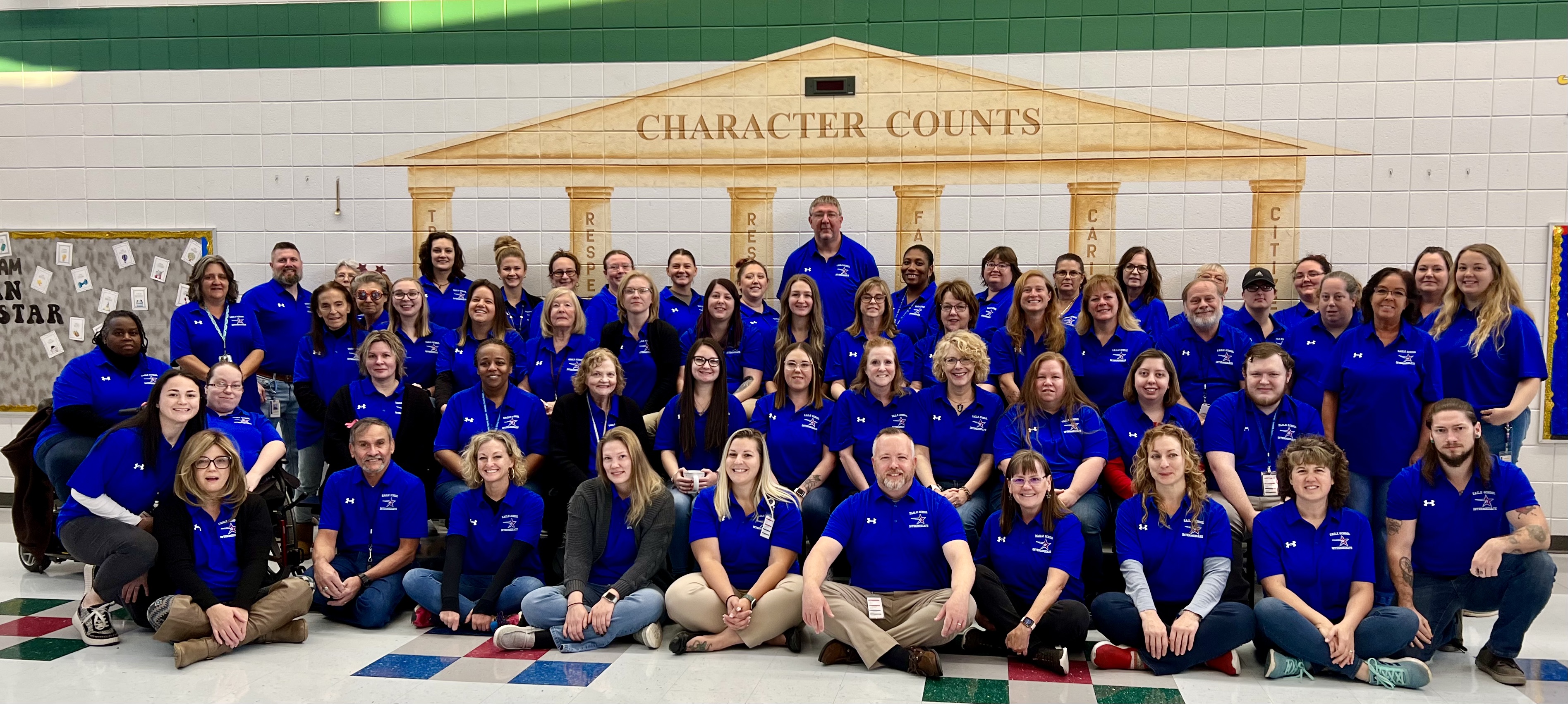 Image shows all of Eagle School Intermediate's staff coming together to stand for an official faculty photo. 