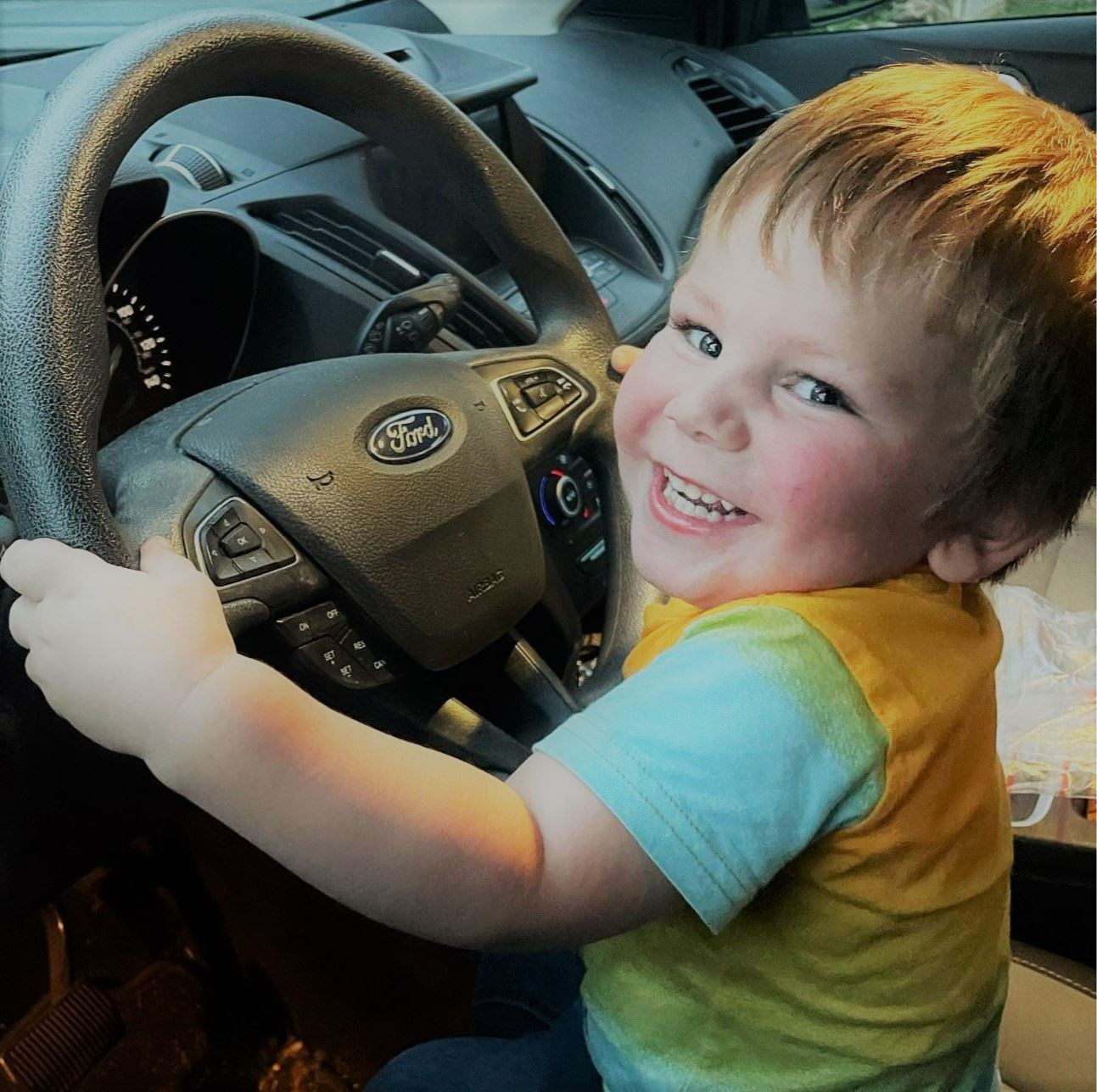 lehi driving baby picture in front of steering wheel