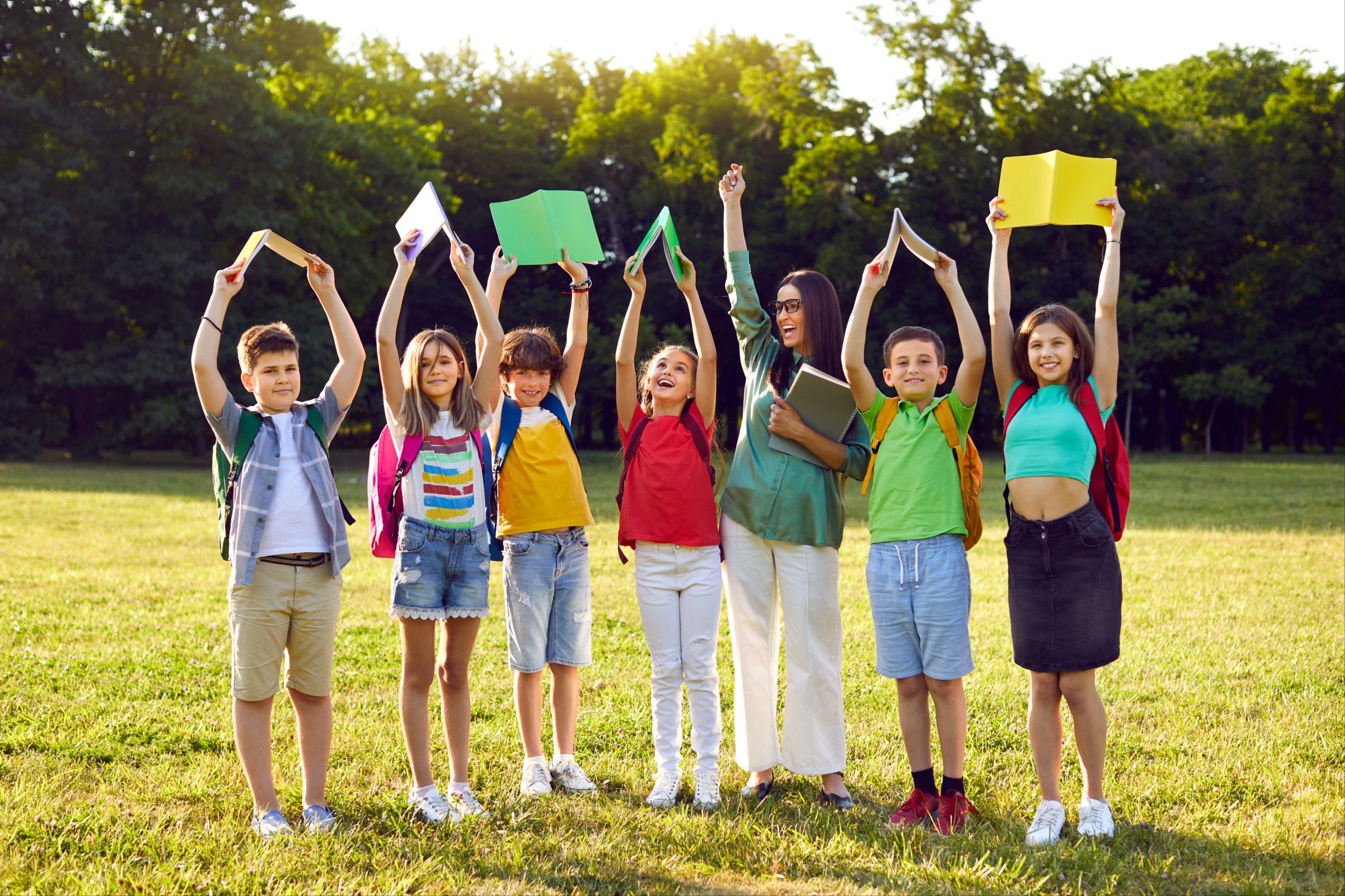 students cheering with books