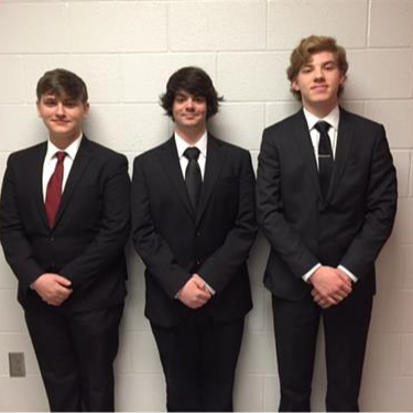 three students dressed in black suits and ties