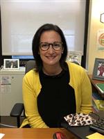 Headshot image of counselor Kennedy wearing a yellow cardigan