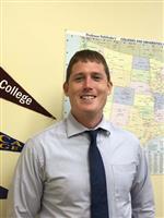 Headshot image of counselor Shanley smiling and wearing a collared shirt and tie