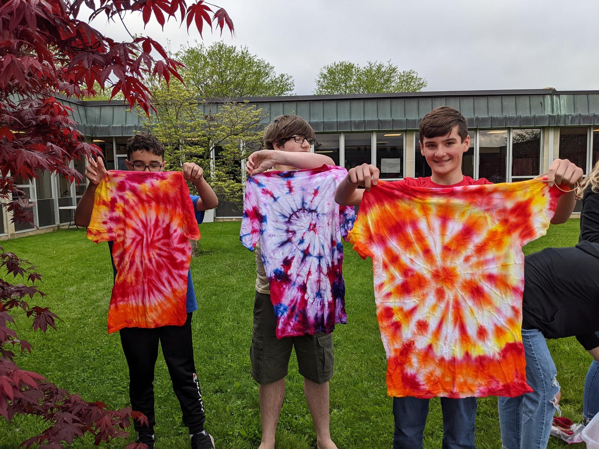 Student holding up their TYE DYE Shirt