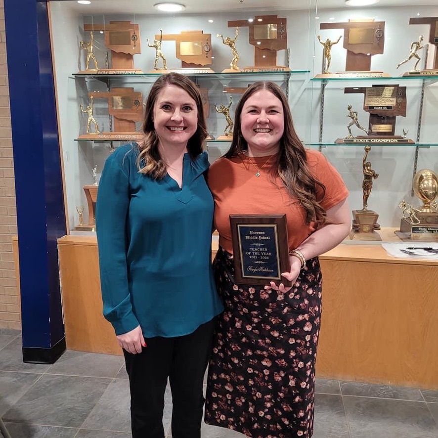 two women hold a plaque