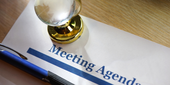 a paperweight holds down a meeting agenda