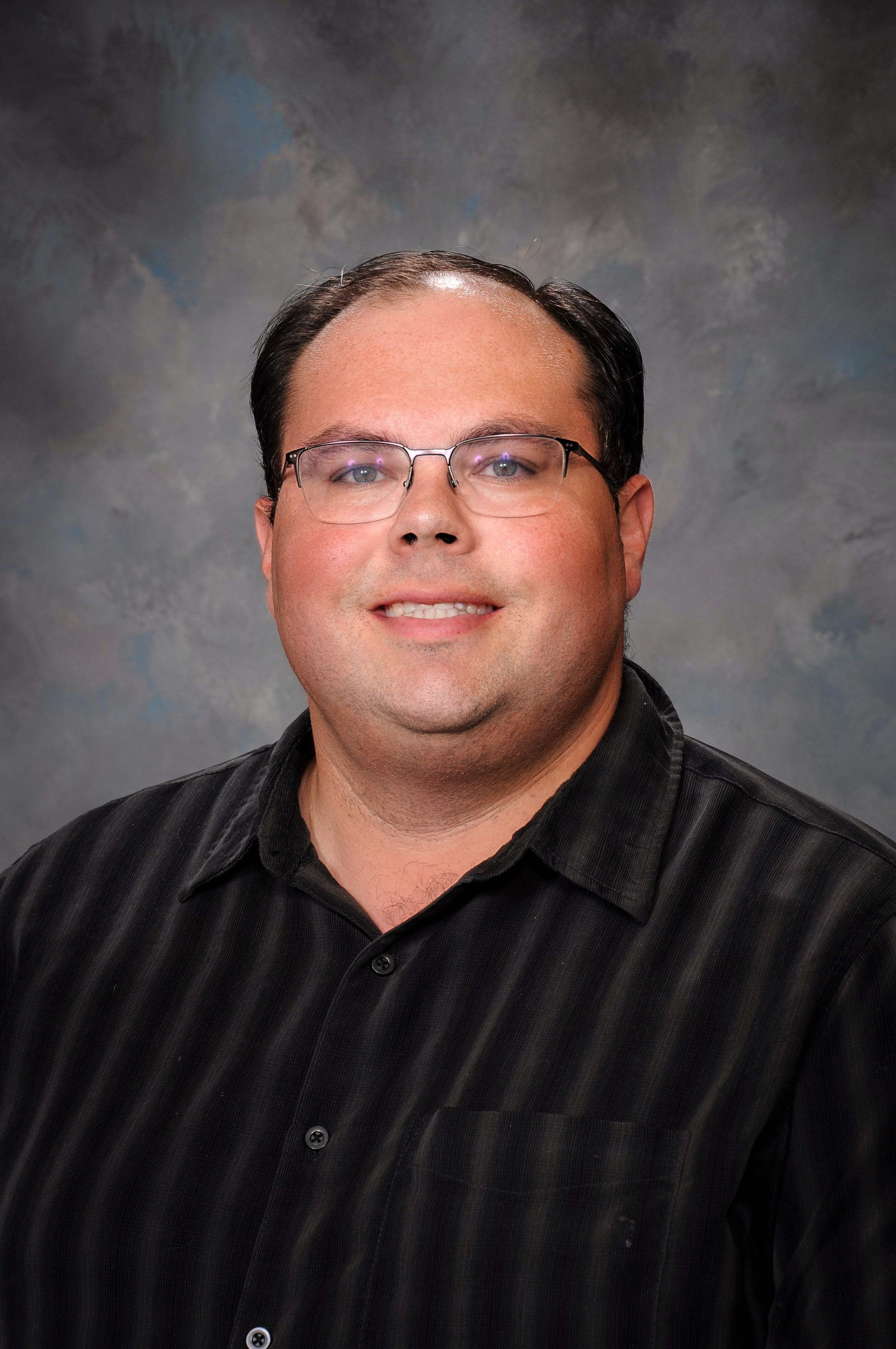 a headshot of a man wearing glasses