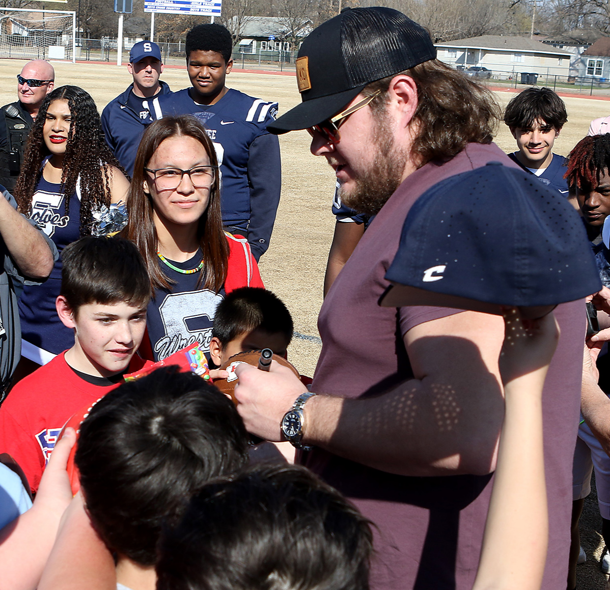 a man signs autographs for children