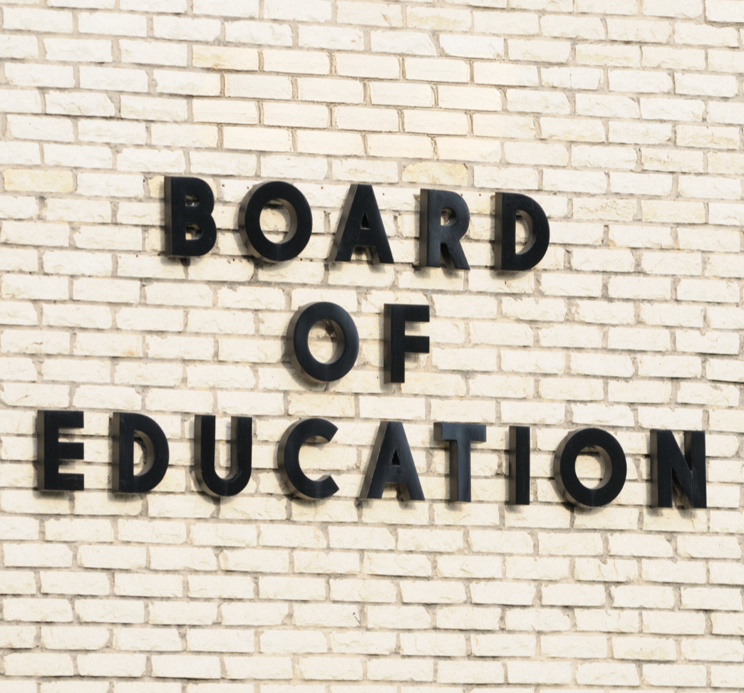 the words board of education on a white brick background