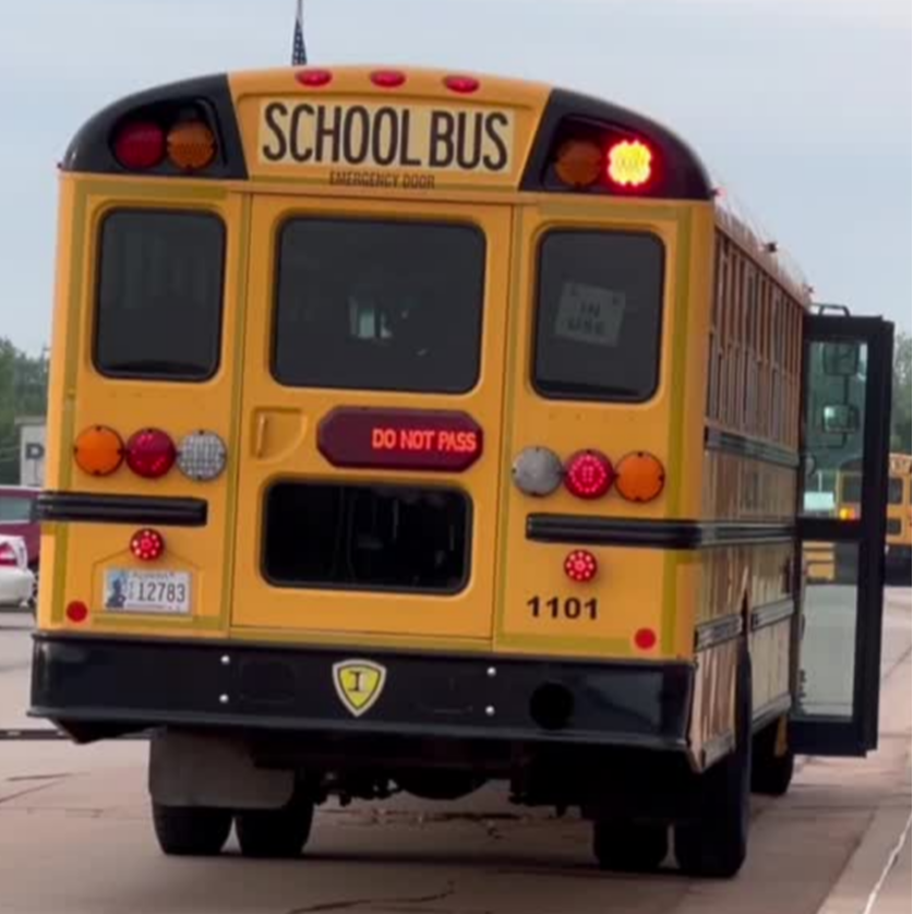 the back of a school bus is parked next to a sidewalk