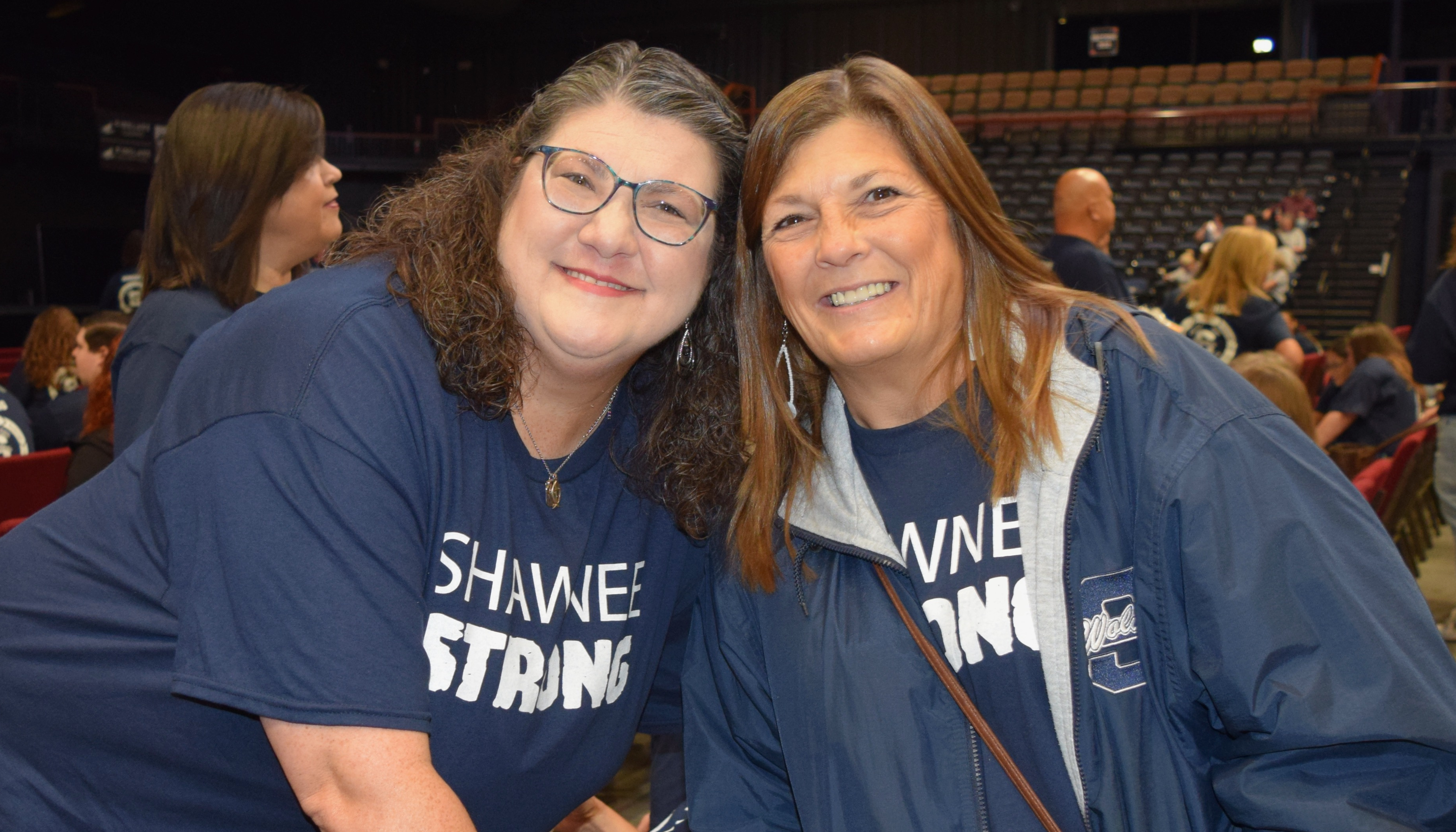 two women wear navy shirts with the words Shawnee STRONG