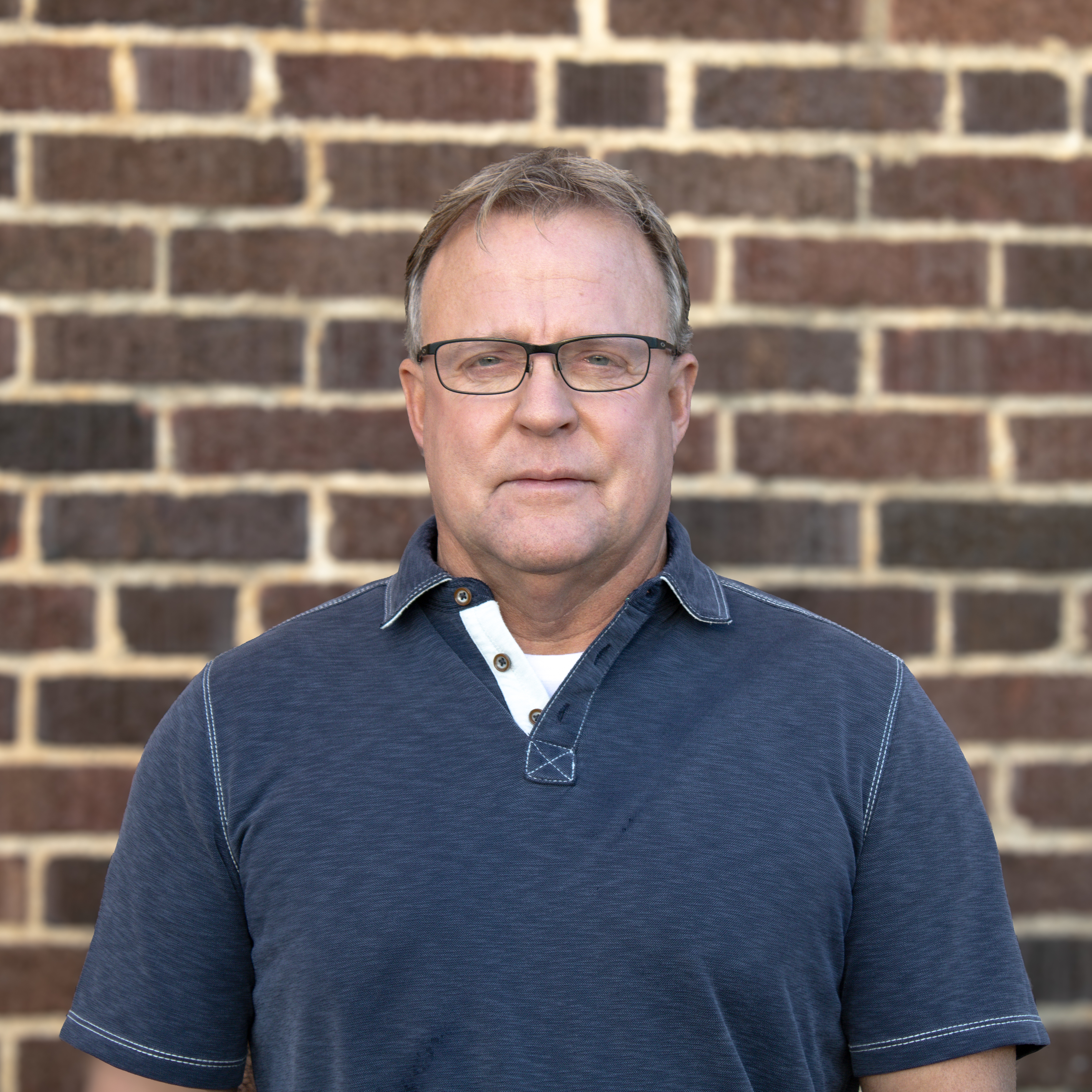 Man in front of brick wall