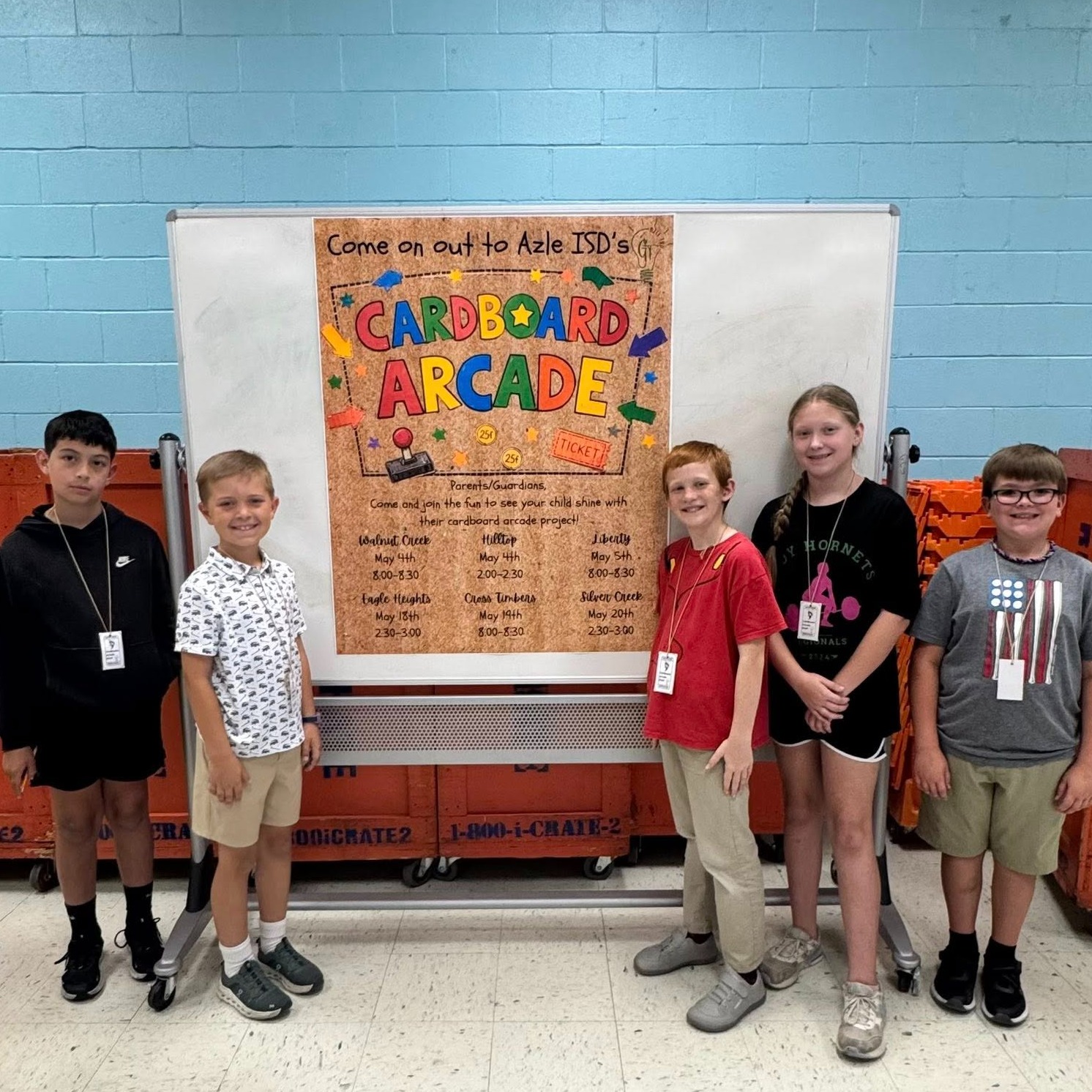 group of elementary students with banner that reads "Come on out to Azle ISD's Cardboard Arcade"
