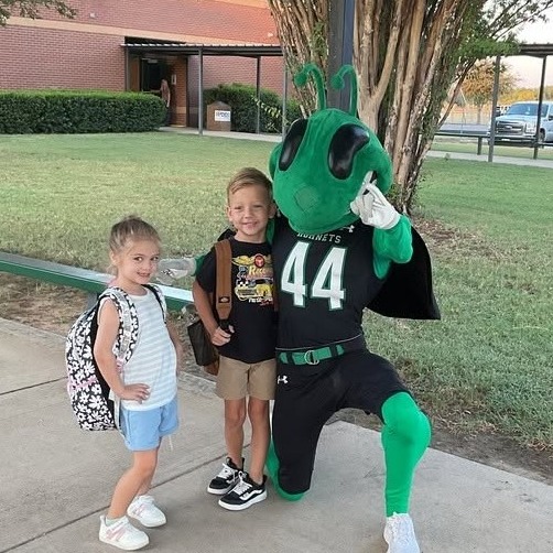 two elementary students outside of school with Buzzy