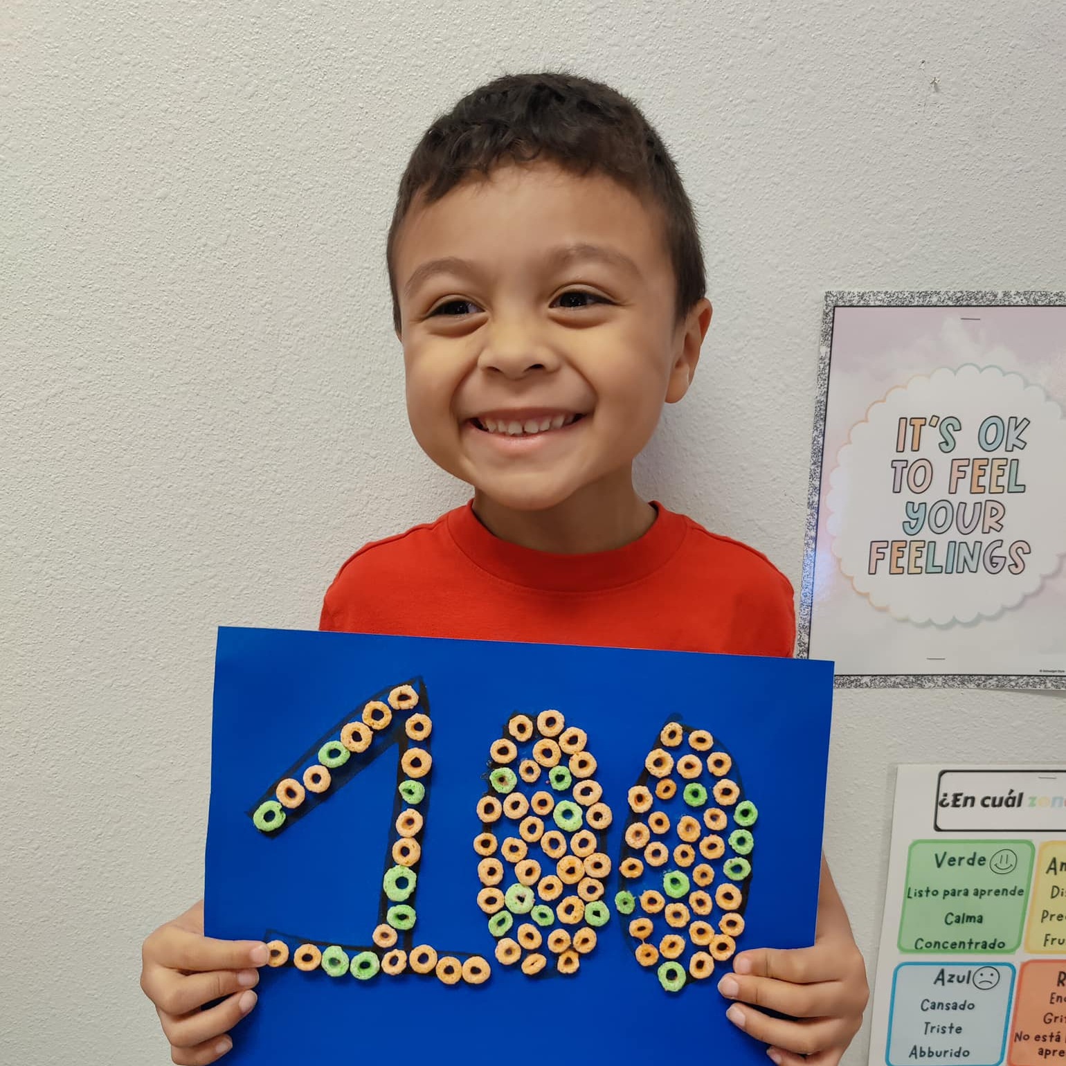 boy holding blue poster with 100 in cereal