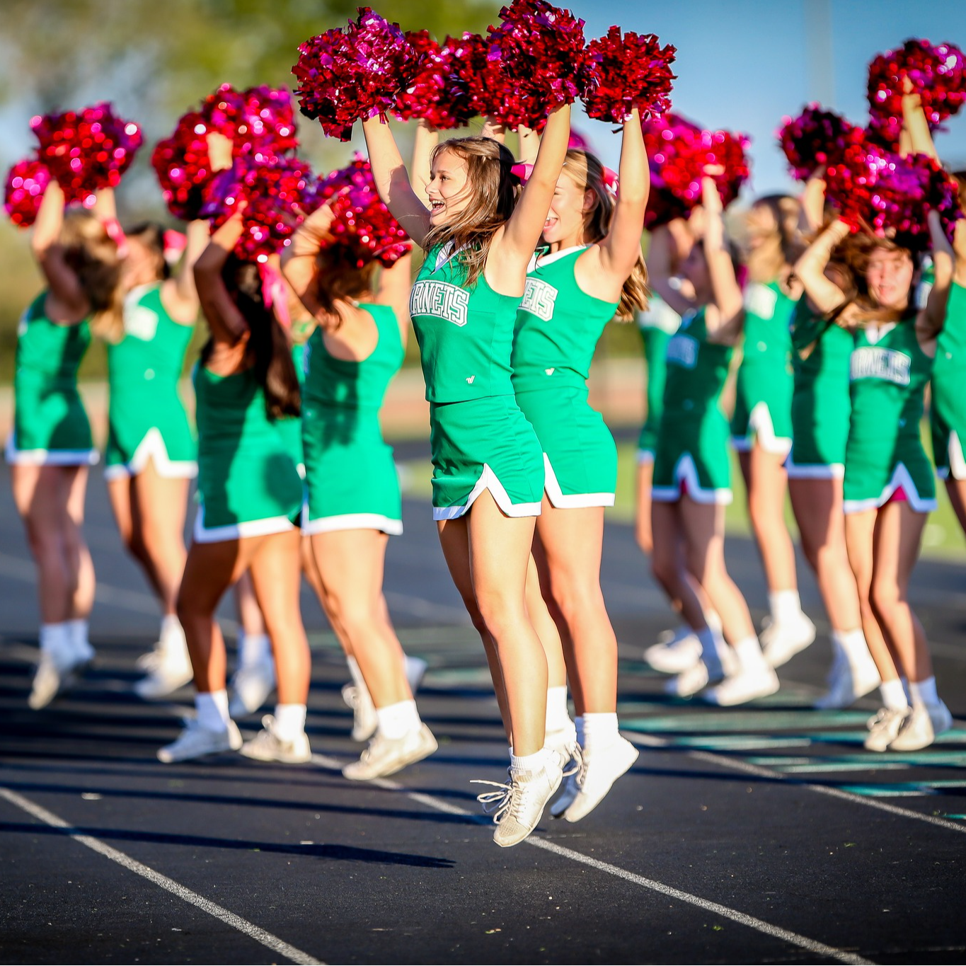 cheerleaders cheering with pink pom poms