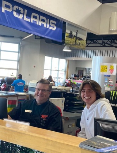 two people sitting behind a store counter