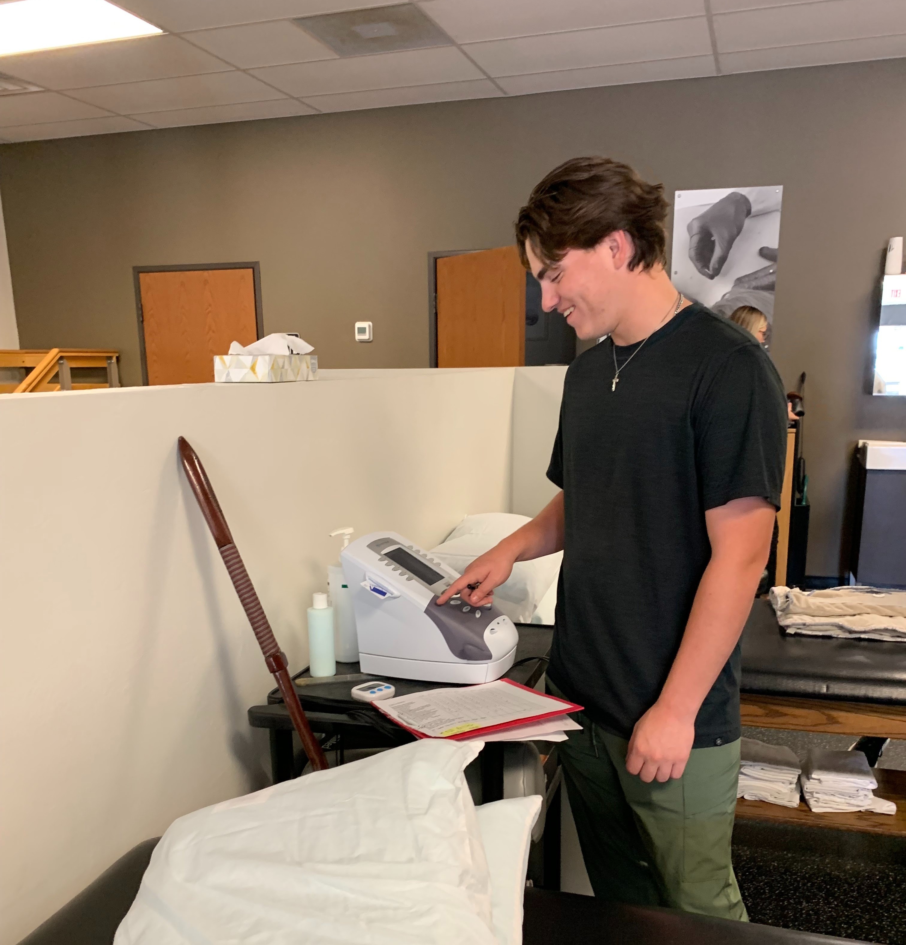 a young man smiles as he uses medical equipment