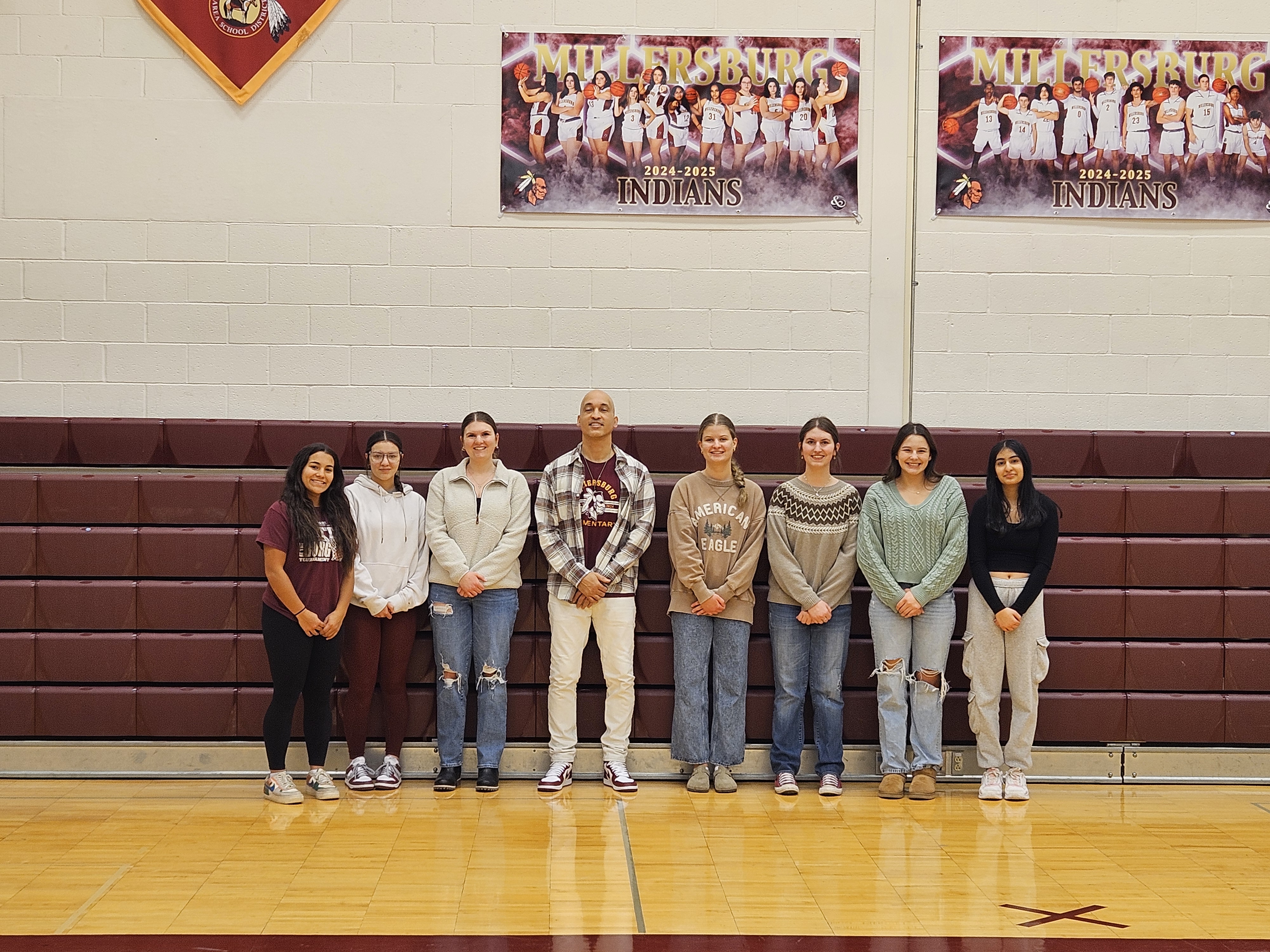 staff and students standing in front of bleachers