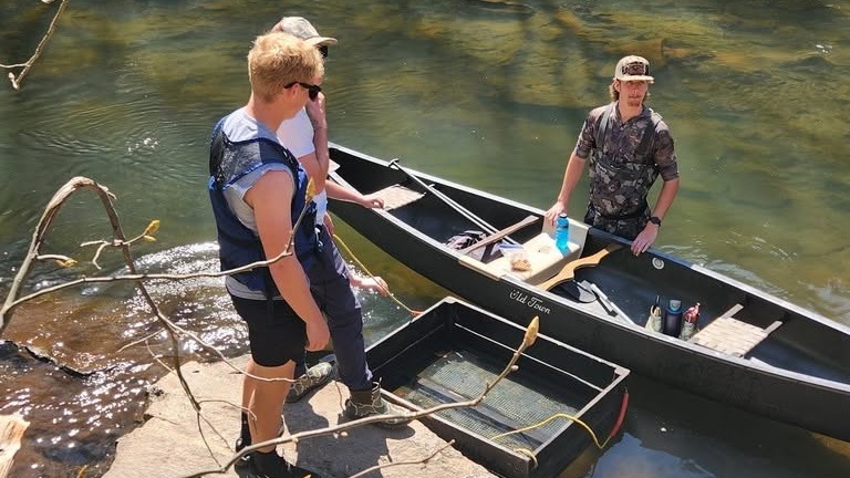 students standing outside with boat