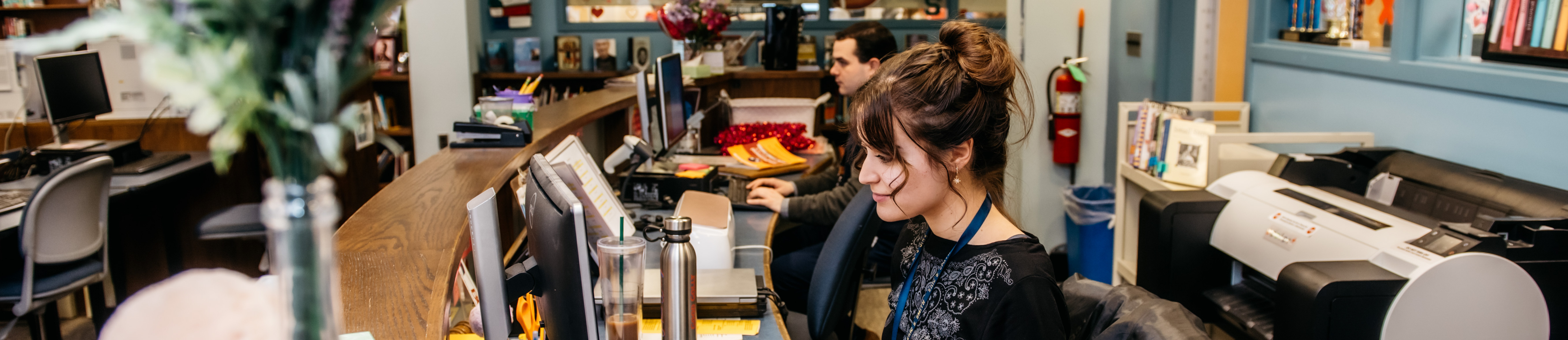 2 staff members sitting in front of computers