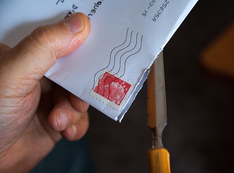 hand holding a letter to be mailed