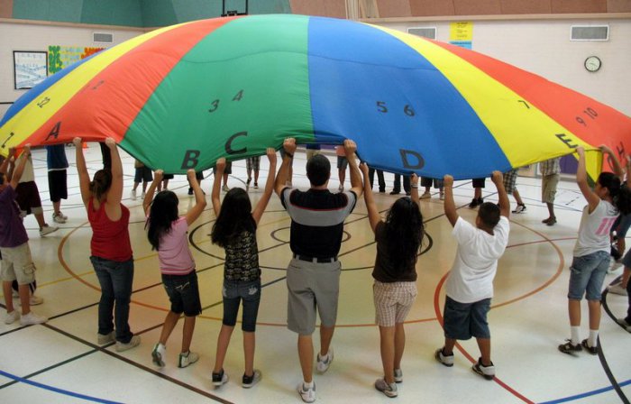 P.E. students and teacher holding up a multi-colored parachute