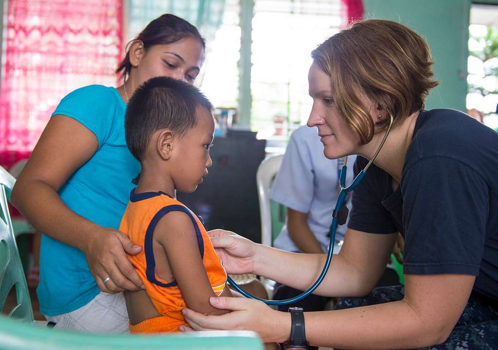 school nurse using a stethoscope with a student