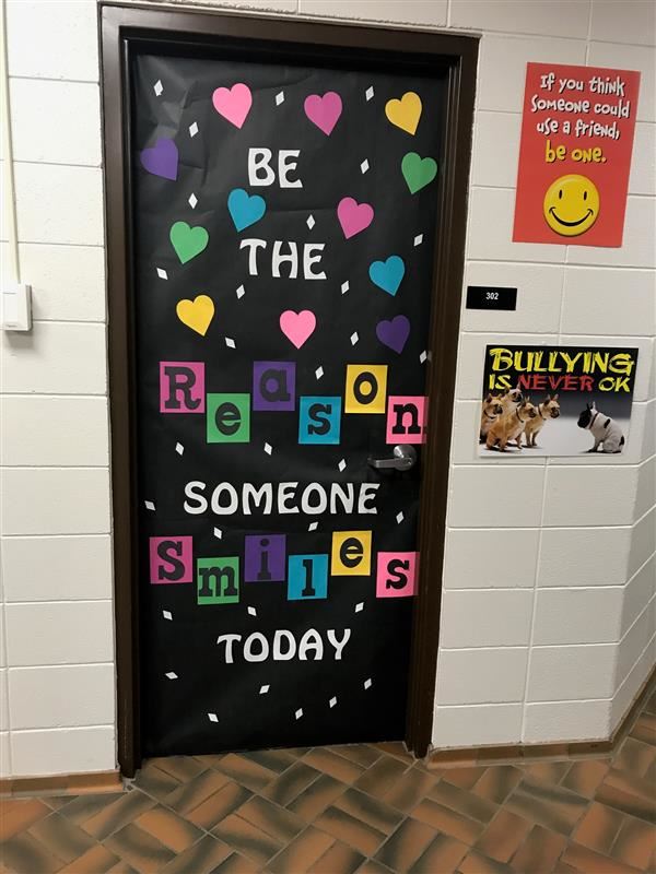 a door decorated to read "Be the reason someone smiles today"