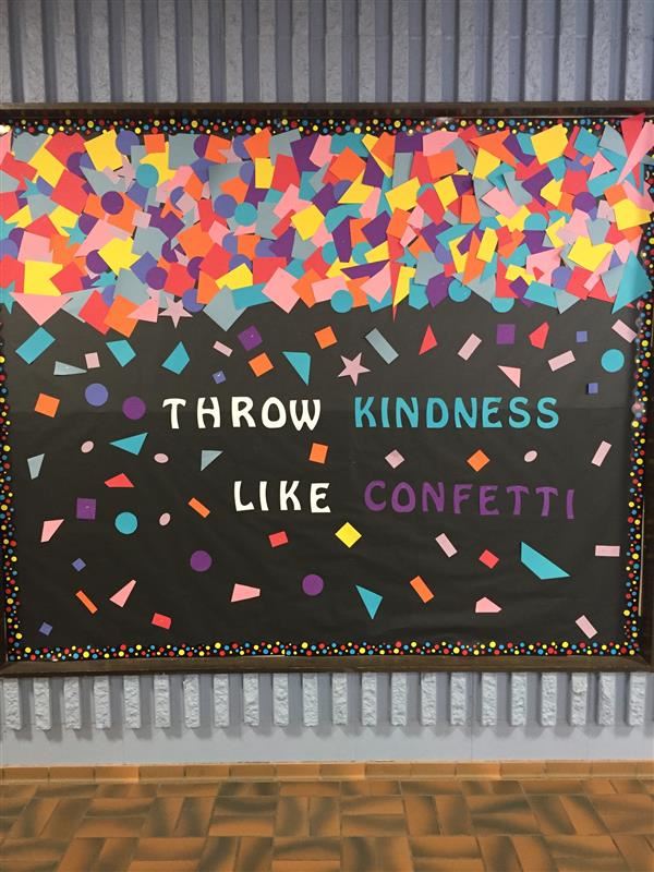a bulletin board decorated with many different colors and shapes of paper with the text "throw kindness like confetti"