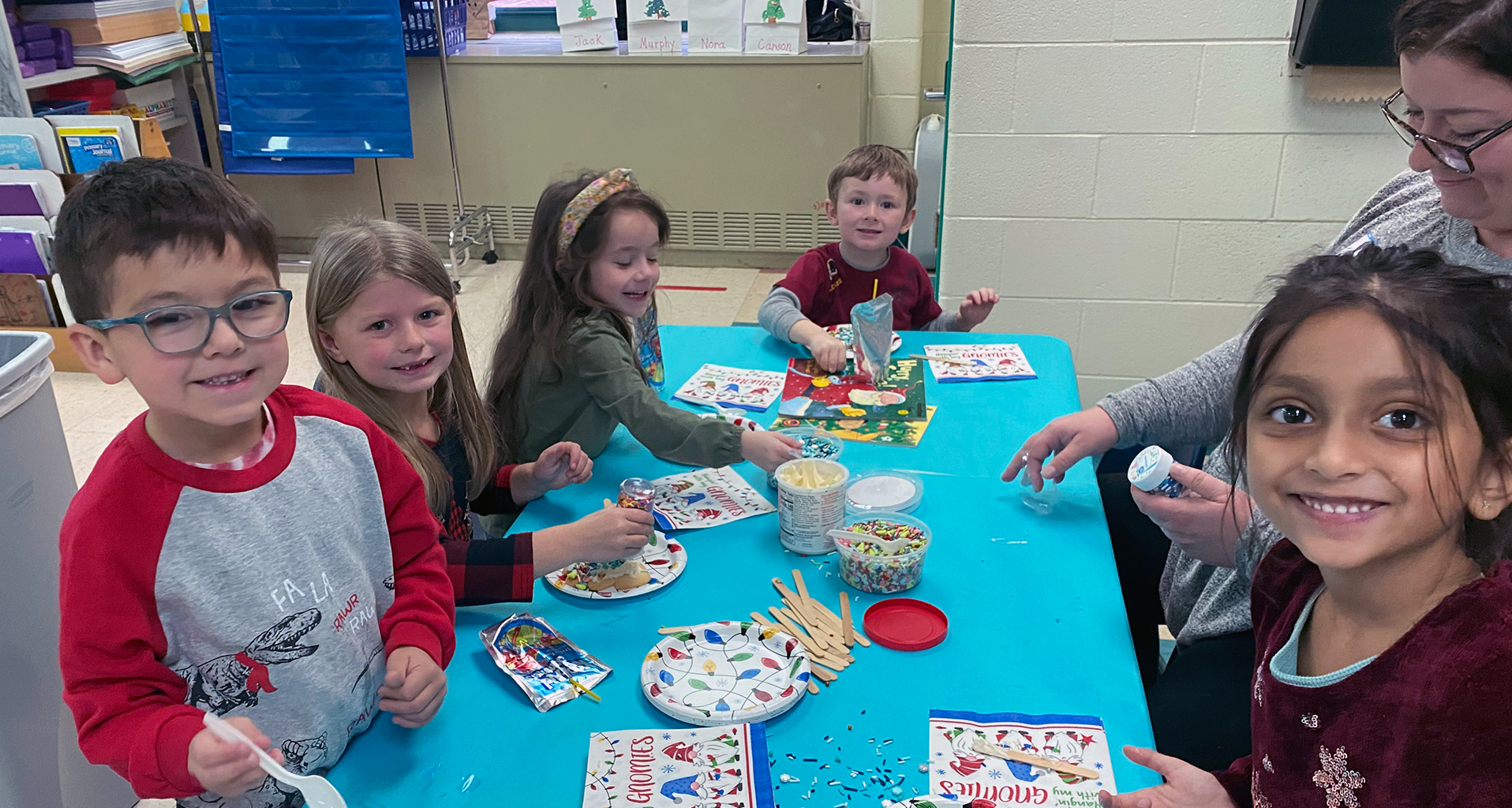 students sitting at the lunch table with food in a lunchbox