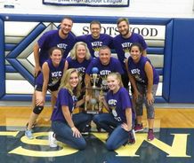 Athletes posing for picture with trophy