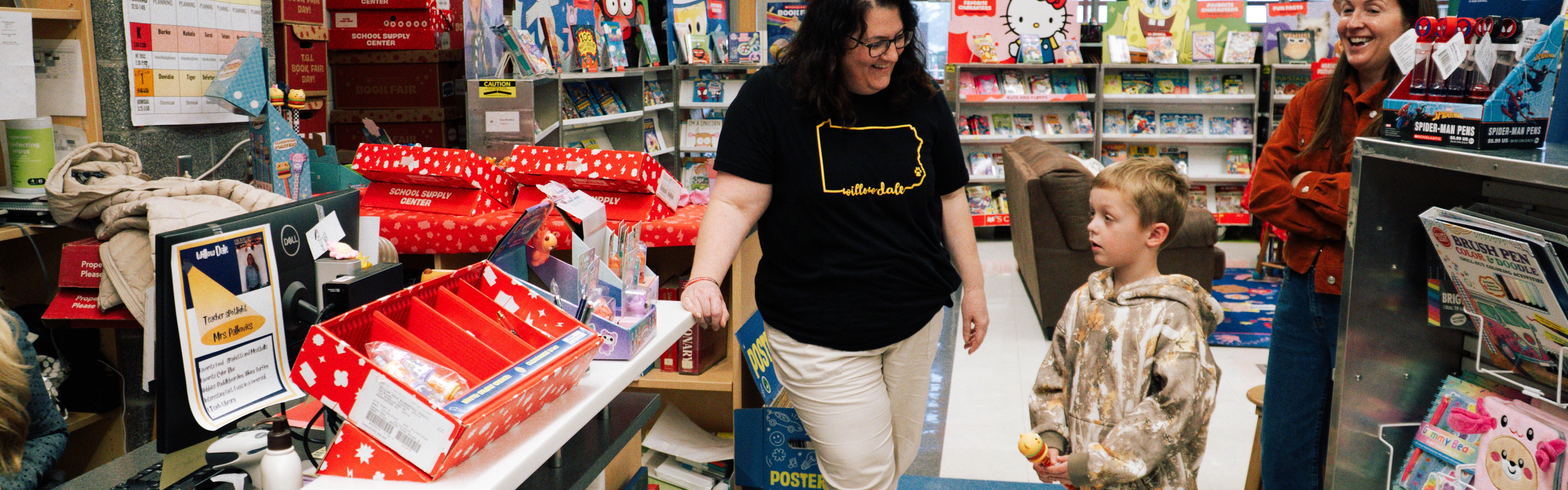 Student and staff member of a school interacting at a book fair