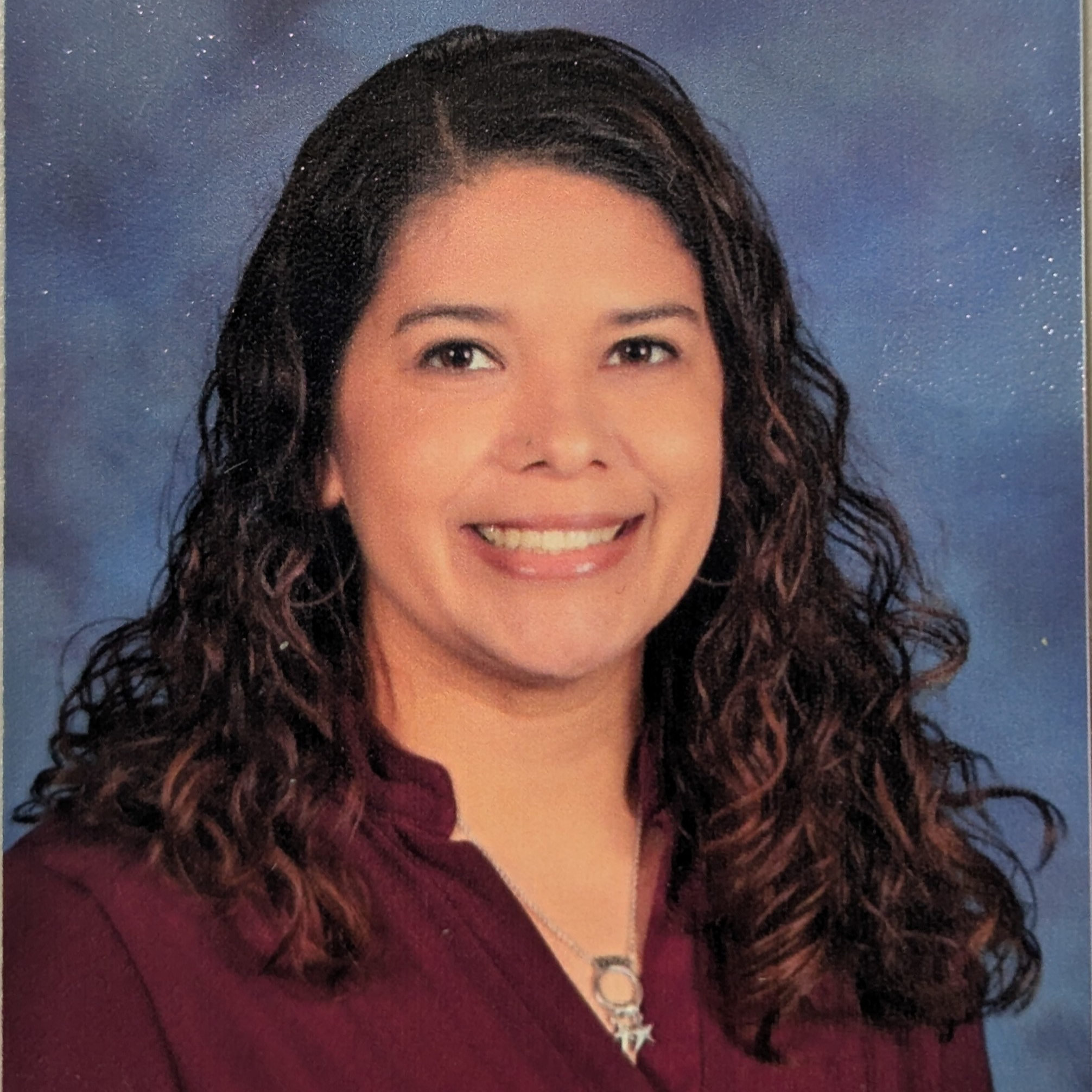 picture of Mrs. Nino from the yearbook smiling wearing a maroon blouse