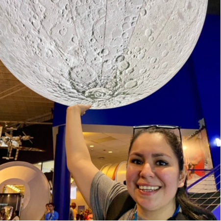 Lorenza Villegas holding a fake moon smiling
