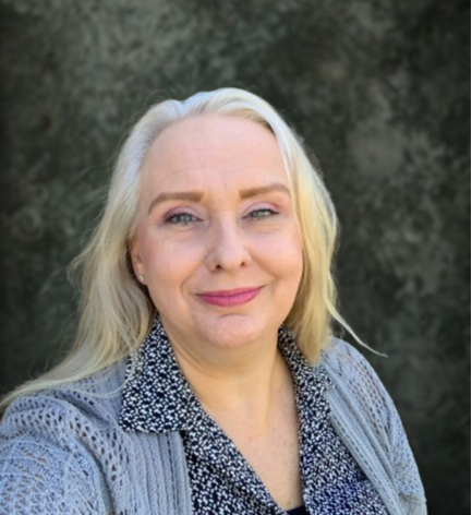 Laurie Newman smiling in selfie wearing a gray sweater