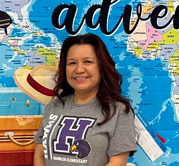Ms. Gonzalez stands in front of our Adventure backdrop at our Back to School Meeting