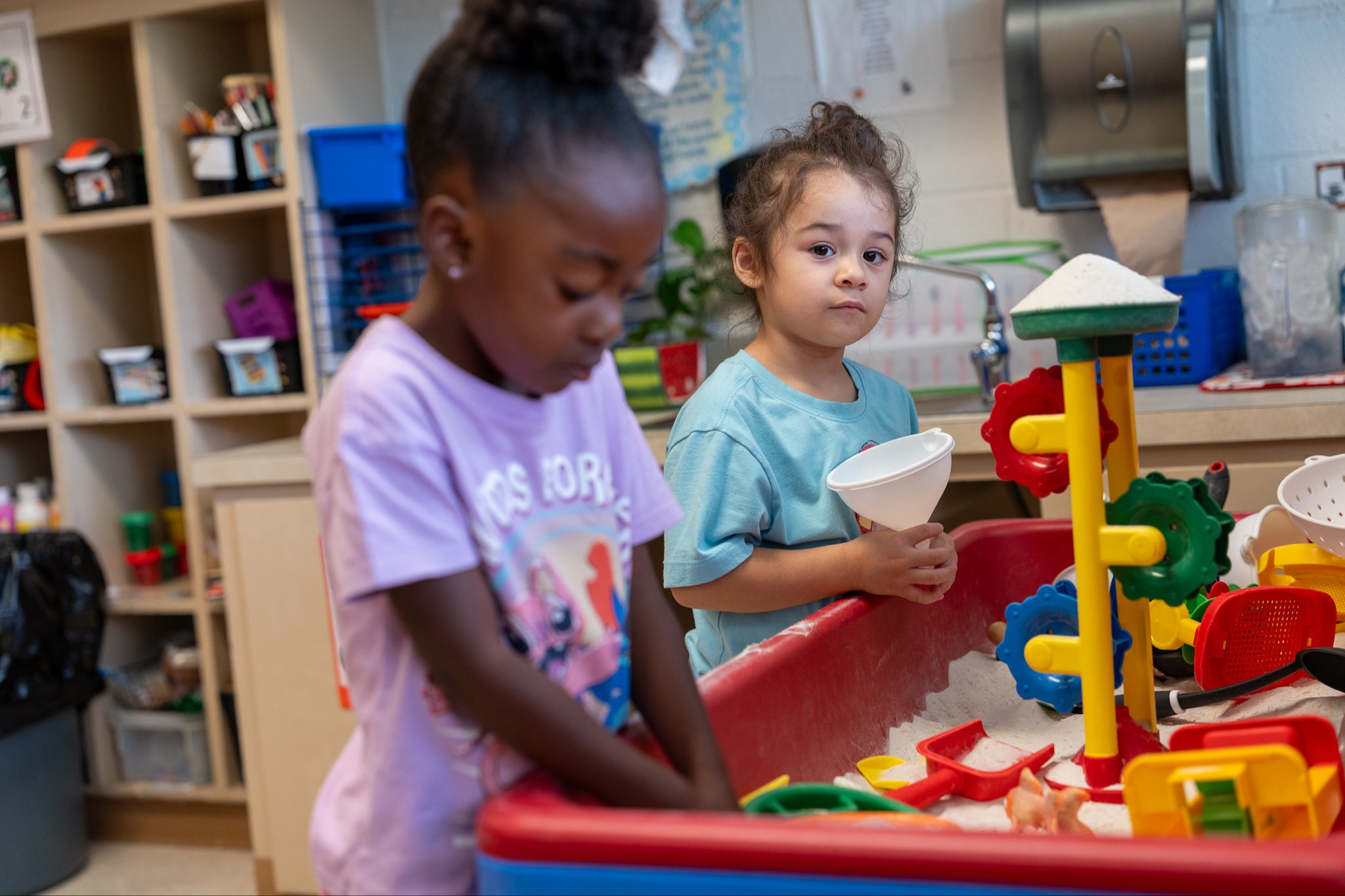 students playing at the sand station