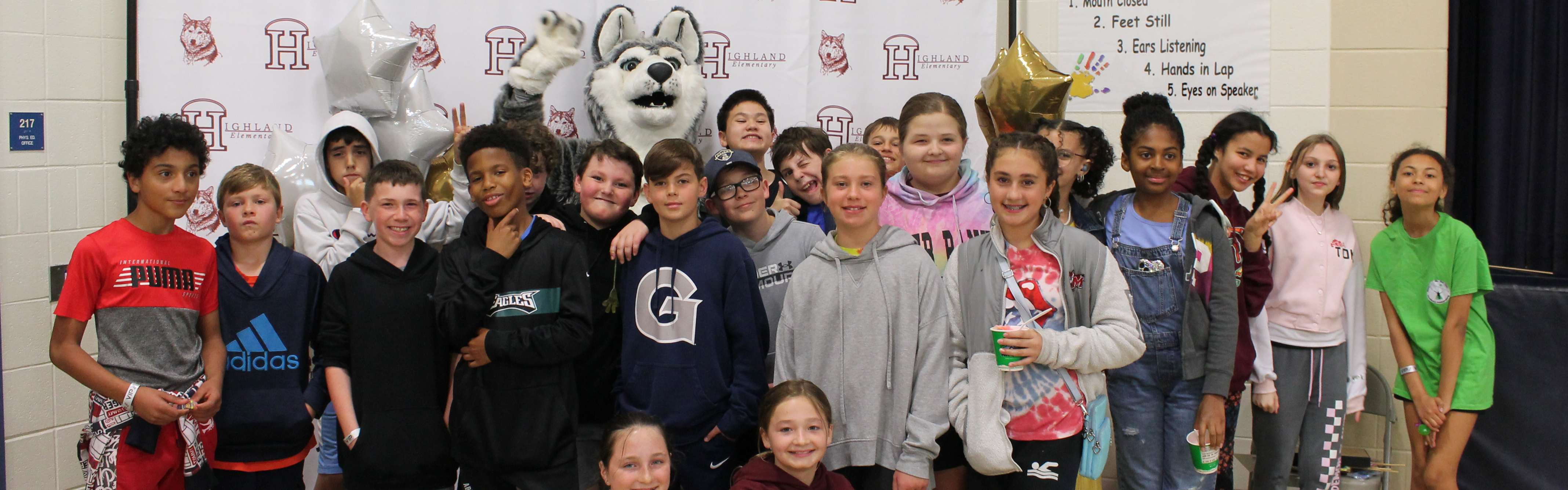 Highland Elementary students posing with the Husky mascot